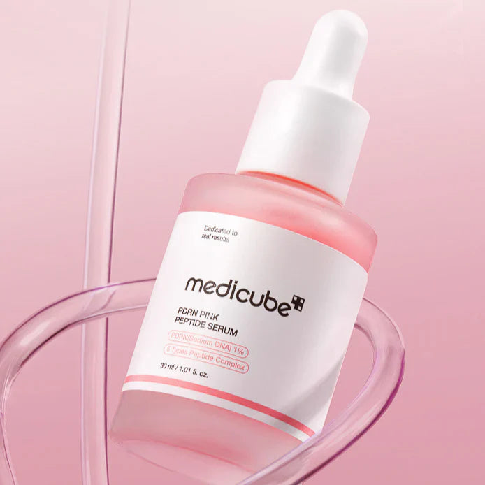 Medicube pink peptide serum bottle with dropper on a pink background
