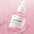 Medicube pink peptide serum bottle with dropper on a pink background