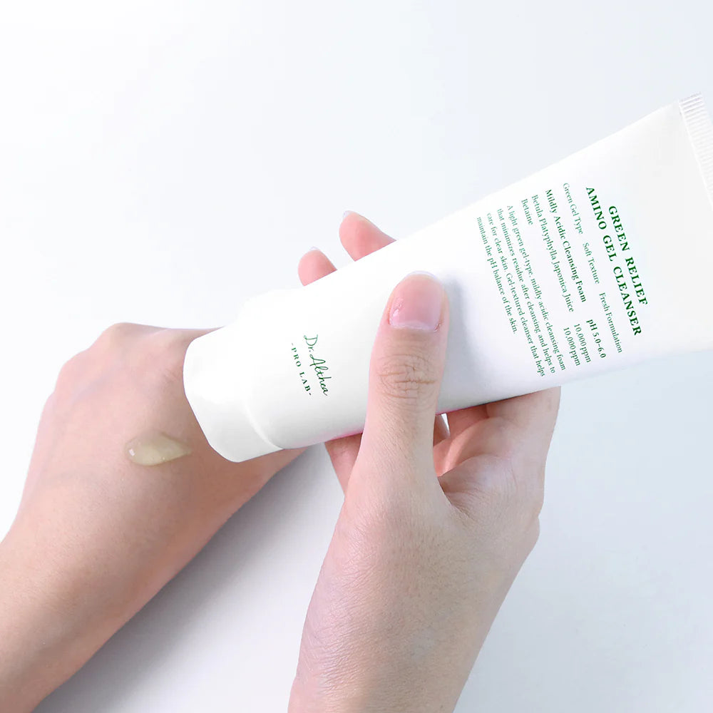 Hand holding a skincare product with visible brand name on a light background