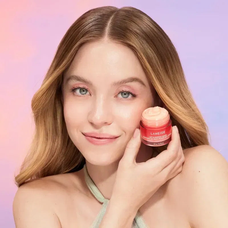 Woman holding a pink jar of Laneige product against a pastel background