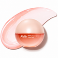 Abib PDRN collagen lip mask in a round translucent peach jar, shown with a glossy pink smear of the glazed jelly behind it on a white background.